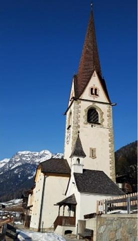 eine Kirche mit einem Uhrturm vor einem Gebäude